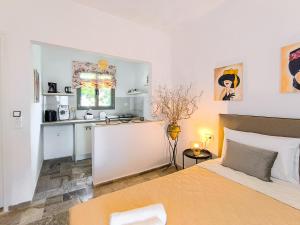a bedroom with a large bed and a kitchen at 3 Goddesses' studios in Koukounaries +25 photos