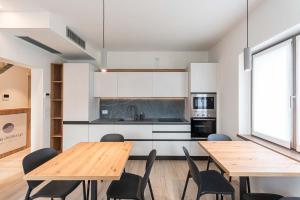 a kitchen and dining room with wooden tables and chairs at Relais del Borgo in Lentiai