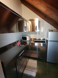 a kitchen with stainless steel counters and a refrigerator at Antico Borgo 2 in Cadarese