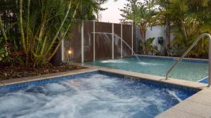 una grande piscina in un cortile con palme di Ocean Pacific Resort - Official a Gold Coast Altre 66 foto