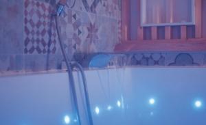 a bathroom with a tub with a toothbrush at Nuit Romantique, Spa, Crémant, Cinéma, Flipper - Escapade Veyloise in Pont-de-Veyle