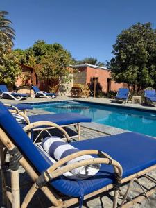 a swimming pool with two deck chairs and a table at El Juneina Villas - Luxury Boutique Villas Near Valley of the Kings in Luxor