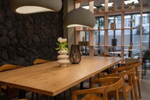 a wooden table with a vase of flowers on it at Esperia Hotel in Larisa