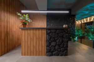 a lobby with a stone wall with plants on it at Esperia Hotel in Larisa