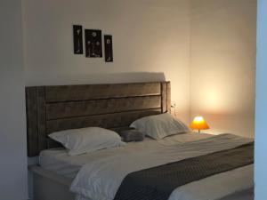 a bedroom with a large bed with white sheets and a lamp at Arctic Inn in Gorakhpur +6 photos