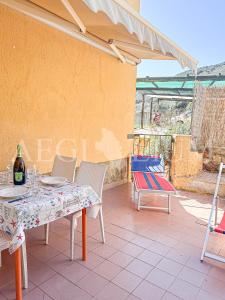 a table and chairs on a patio with a bottle of wine at Ginestra in Campese
