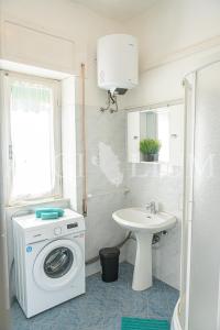 a bathroom with a washing machine and a sink at Ginestra in Campese