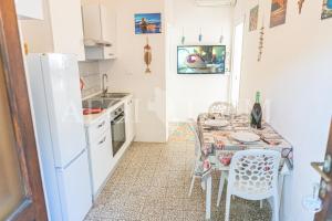 a kitchen with a table and a white refrigerator at Ginestra in Campese