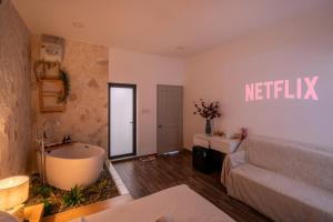 a living room with a bath tub and a couch at Chạm's Hotel & Homestay in Ho Chi Minh City