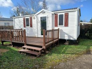 a white tiny house with a wooden deck at Escapade aux Peupliers in Vironchaux