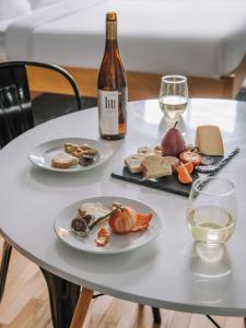 a table with two plates of food and a bottle of wine at The Alexander - Old Montreal in Montreal