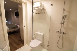 a bathroom with a shower with a toilet and a glass door at Rossio Garden Suites in Lisbon +39 photos