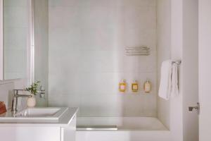 a white bathroom with a sink and a mirror at The Alexander - Old Montreal in Montreal