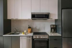 a kitchen with a stove and a sink and a microwave at The Alexander - Old Montreal in Montreal