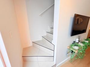 a stairwell with a tv and a television on a wall at Little Acorn in Hermanus