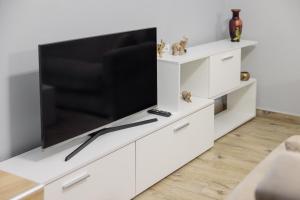 a white entertainment center with a large flat screen tv at Γιώργος και Εύα in Karianí