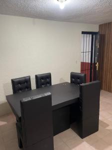 a conference room with a black table and chairs at Casa Fuentes in Zacatlán