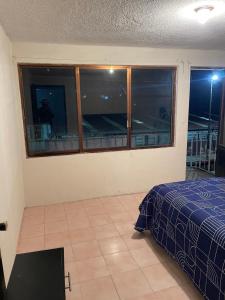 a bedroom with a bed and a window with a balcony at Casa Fuentes in Zacatlán
