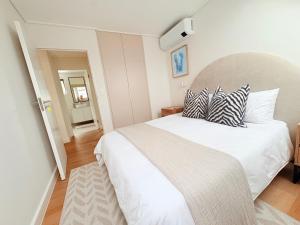 a bedroom with a large white bed with pillows at Little Acorn in Hermanus