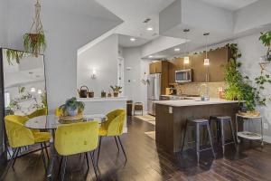 a kitchen and dining room with a table and yellow chairs at Spacious Denver Home with Private Rooftop Spa in Denver