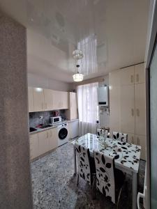 a kitchen with a table with chairs and a dining room at Central Apartment Tskaltubo in Tsqaltubo