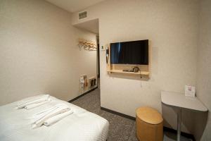 a hotel room with a bed and a flat screen tv at Hotel Il Fiore Kasai Annex in Tokyo
