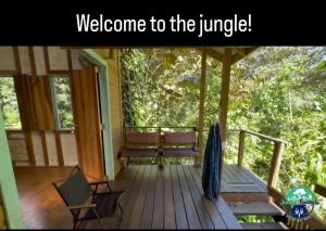 a porch with chairs and an umbrella and the words welcome to the jungle at Jungle Paunch in Bocas Town