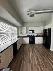 a large kitchen with white cabinets and black appliances at Graphite Loft in Des Moines