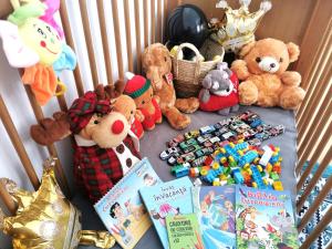a group of stuffed animals and books in a crib at Little Bear Busteni - Închiriere integrală, cameră de jocuri, parcare privată, potrivită și pentru munca la distanță in Buşteni