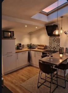 a kitchen with a table and chairs in a room at Nuit Romantique, Spa, Crémant, Cinéma, Flipper - Escapade Veyloise in Pont-de-Veyle