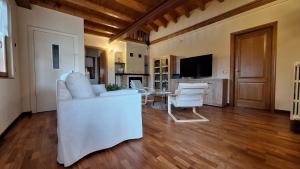 a living room with a white couch and a table at piccola Villa La Palma in Colazza