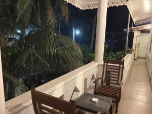 two chairs and a table on a balcony at night at Fairview Villa in Hikkaduwa