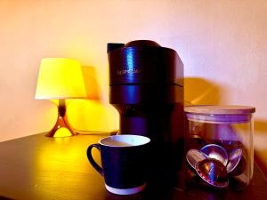 a coffee maker and a cup on a table at La Ferme des Roses in Tournai