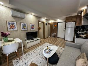 a living room with a couch and a kitchen at Smartly Designed Cozy 1BR Apartment in Antalya