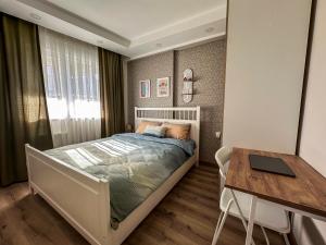 a bedroom with a bed and a table and a desk at Smartly Designed Cozy 1BR Apartment in Antalya