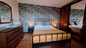 a bedroom with a bed and floral wallpaper at piccola Villa La Palma in Colazza