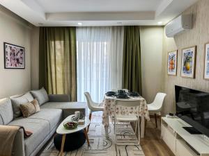 a living room with a couch and a table at Smartly Designed Cozy 1BR Apartment in Antalya