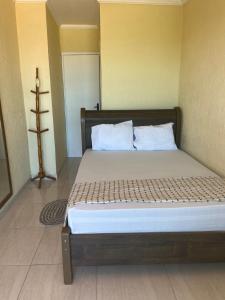 a bedroom with a large bed with white pillows at Surf Zone Hostel in Saquarema +16 photos
