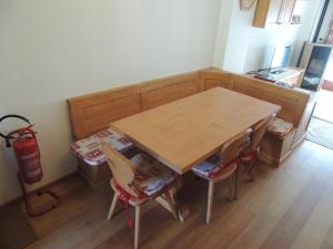 a kitchen with a wooden table and chairs and a fire extinguisher at Ai Margini del Bosco in Sappada