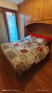 a bed with a quilt on it in a bedroom at Ai Margini del Bosco in Sappada