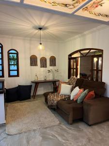 a living room with a couch and a table at Hospedagem Flor de Alissah in Arraial do Cabo