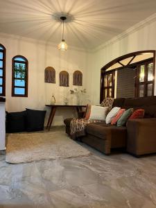 a living room with a couch and a table at Hospedagem Flor de Alissah in Arraial do Cabo
