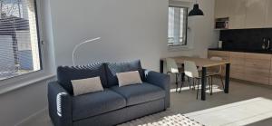 a living room with a blue couch and a table at River2Mountain Cozy Apartment in Gozd Martuljek +17 photos