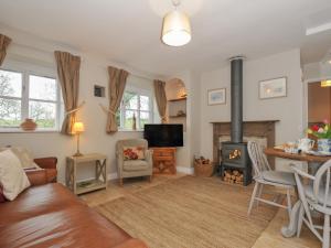 a living room with a couch and a fireplace at Stocks Barn in Liskeard