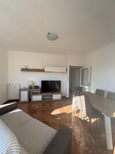 a living room with a dining table and a television at Casa Francesco in Rapallo