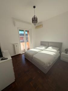 a bedroom with a large white bed and a television at Casa Francesco in Rapallo