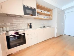 a kitchen with white cabinets and a stove top oven at Little Acorn in Hermanus