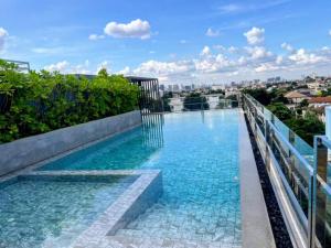 a swimming pool on top of a building at Bangkok Esque Sukhumvit101 Condo NEW Building in Amphoe Phra Khanong
