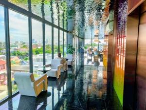 a lobby with chairs and a colorful ceiling at Bangkok Esque Sukhumvit101 Condo NEW Building in Amphoe Phra Khanong