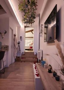 a room with a hallway with stairs and a chandelier at Nuit Romantique, Spa, Crémant, Cinéma, Flipper - Escapade Veyloise in Pont-de-Veyle